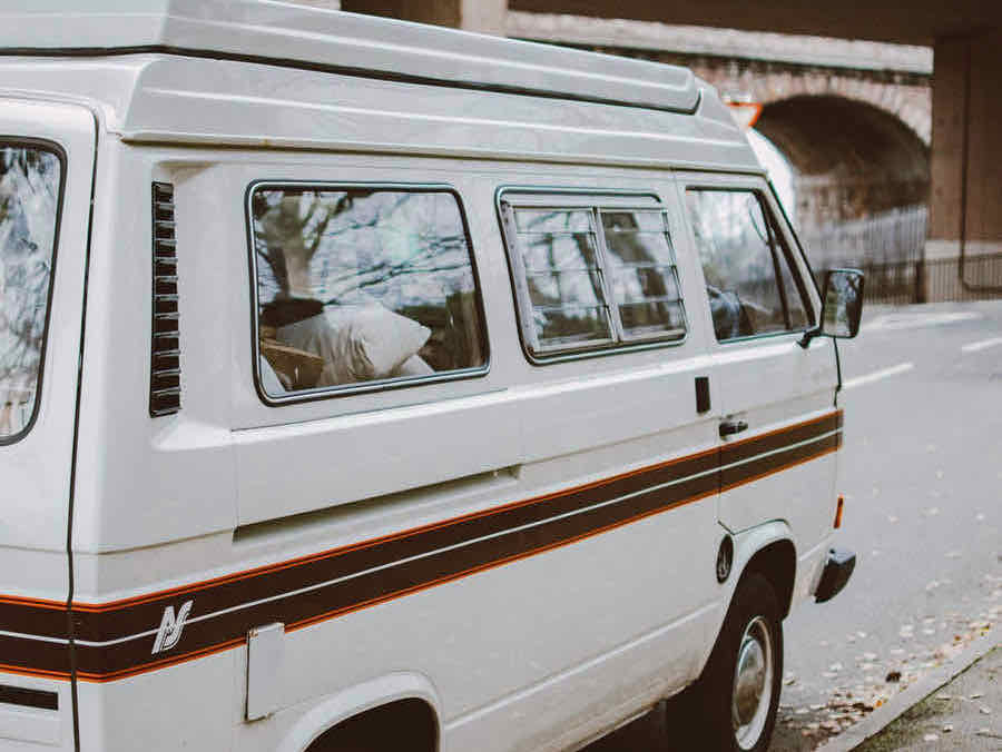 White camping van parked on street.