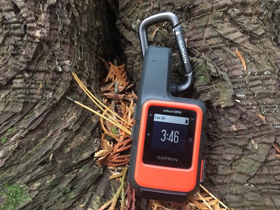 Front view of Garmin inReach Mini outside with screen turned on to home.